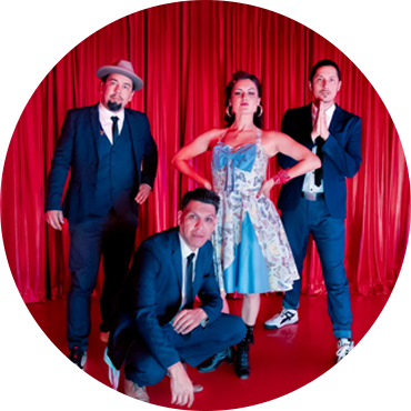 The band poses together against a red backdrop