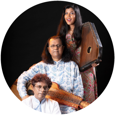 Anandi, Debashish, and Subhasis Bhattacharya pose with a slide guitar and swarmandal (small harp) against a black background.