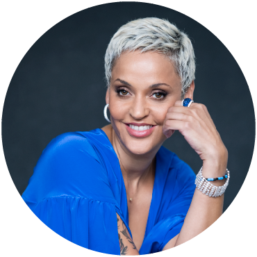 Singer Mariza smiles and wears blue with her hand pressed to her face.