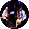 Omar Sosa (left) plays the guitar next to Seckou Keita (right) playing the kora on stage