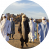 6 members of the band wearing full scarfs walk through the desert